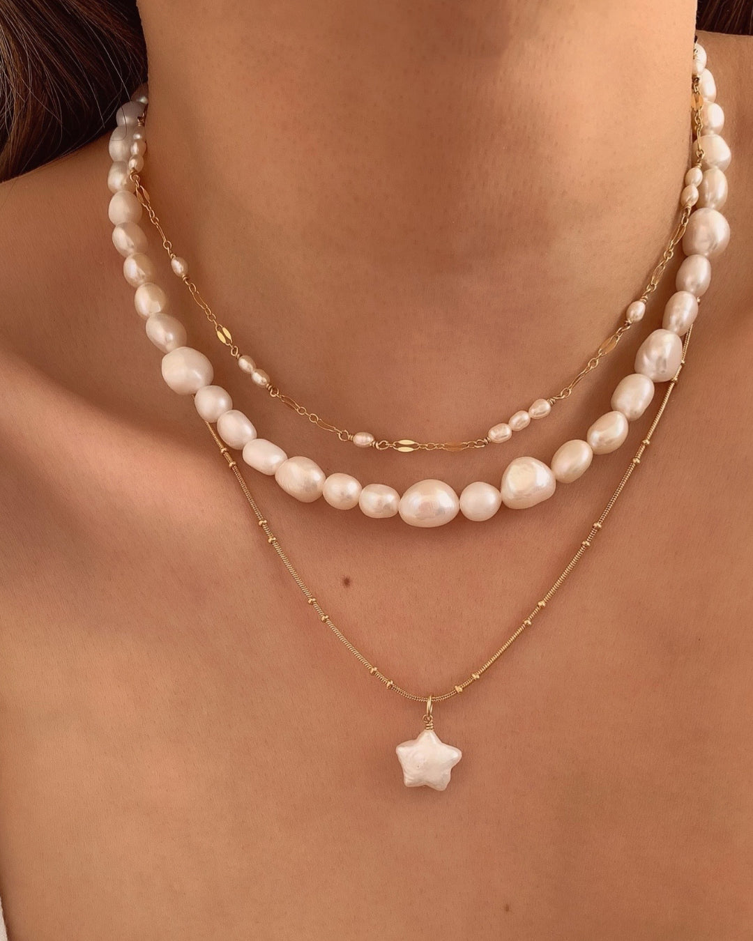 Australian-designed Baroque Pearl Necklace featuring natural, irregular baroque pearls for a classic, elegant statement. Styled on a model, layered with Star Pearl Necklace and Stardust Pearl Choker.