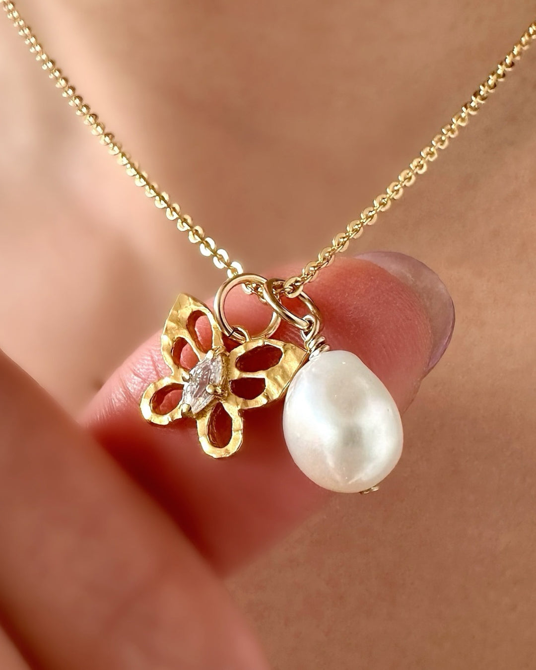 Model wearing Romyli classic pearl pendant on gold fill bail paired with classic cable and buyterfly pendant – layered Australian jewellery styling.