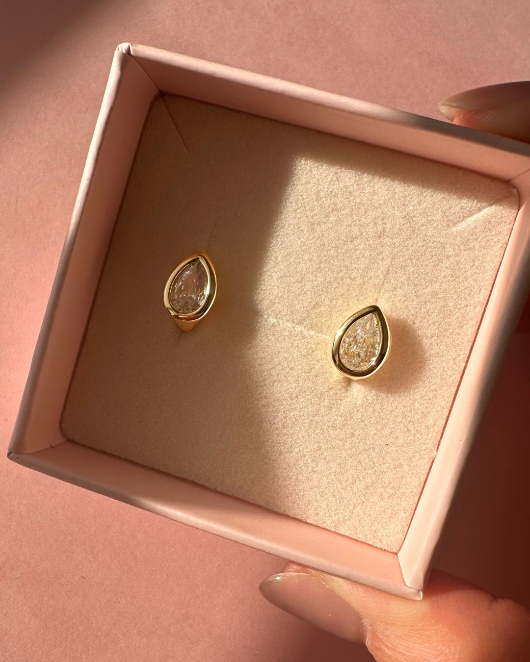 Gold teardrop bezel Huggie hoop earrings in a pink Romyli gift box
