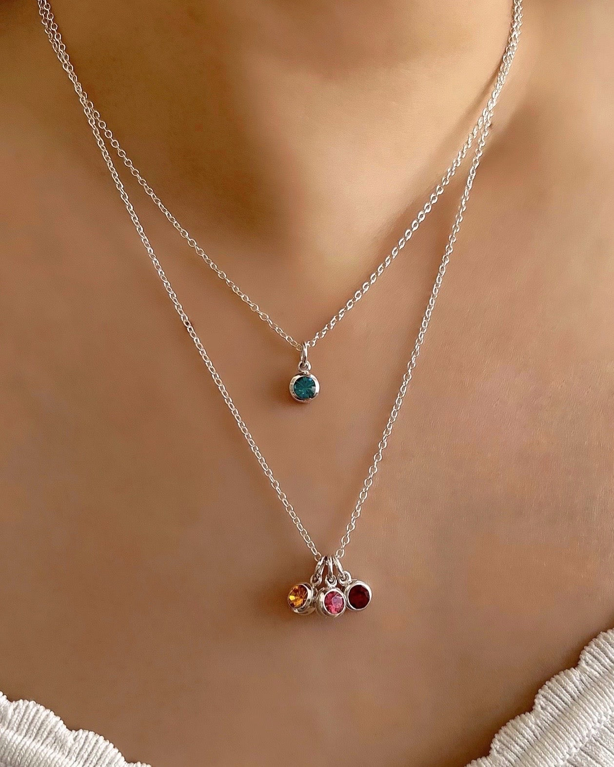 Sterling Silver Birthstone Necklace in May Emerald birthstone, November Citrine birthstone, Pink tourmaline October birthstone and January red garnet birthstone on a model 