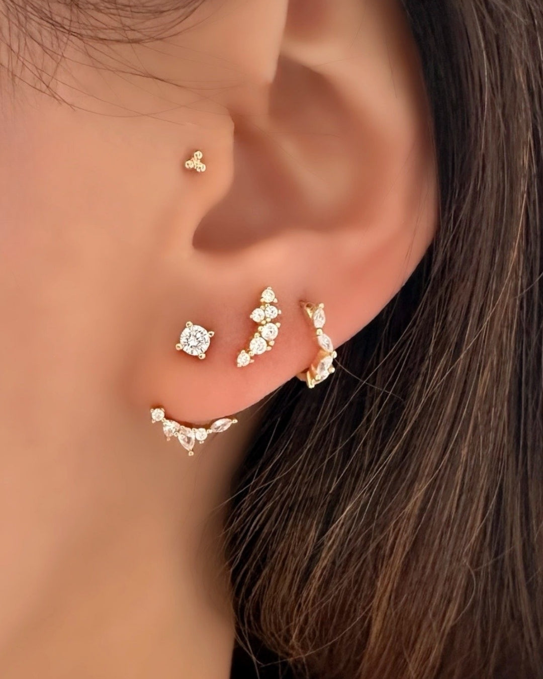 Model wearing Gold ear jacket earrings with mixed crystal shapes – teardrop, marquise, and round cut sparkle. Stacked with Fleck Climber Studs and Fleck Marquise Huggies 