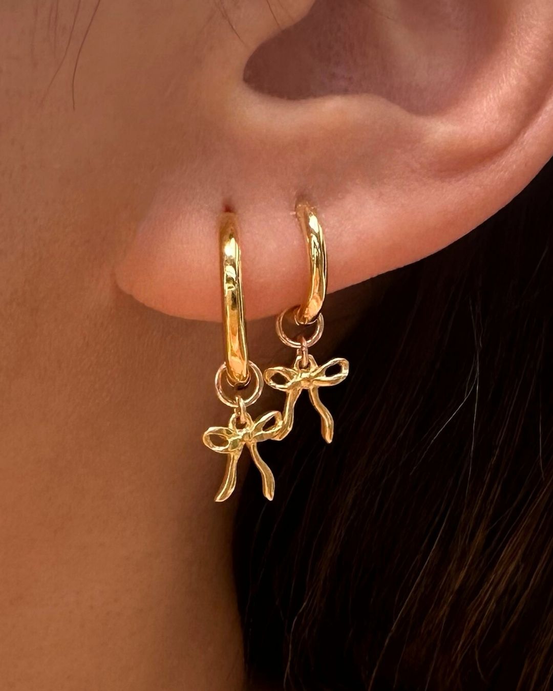 Model wearing Bow Charm Hoop Earrings - featuring medium 23mm hoops and small 16mm hoops