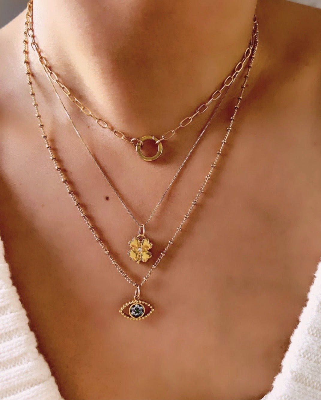 Gold fill clover blossom flower talisman protection pendant on a gold necklace chain on a model 