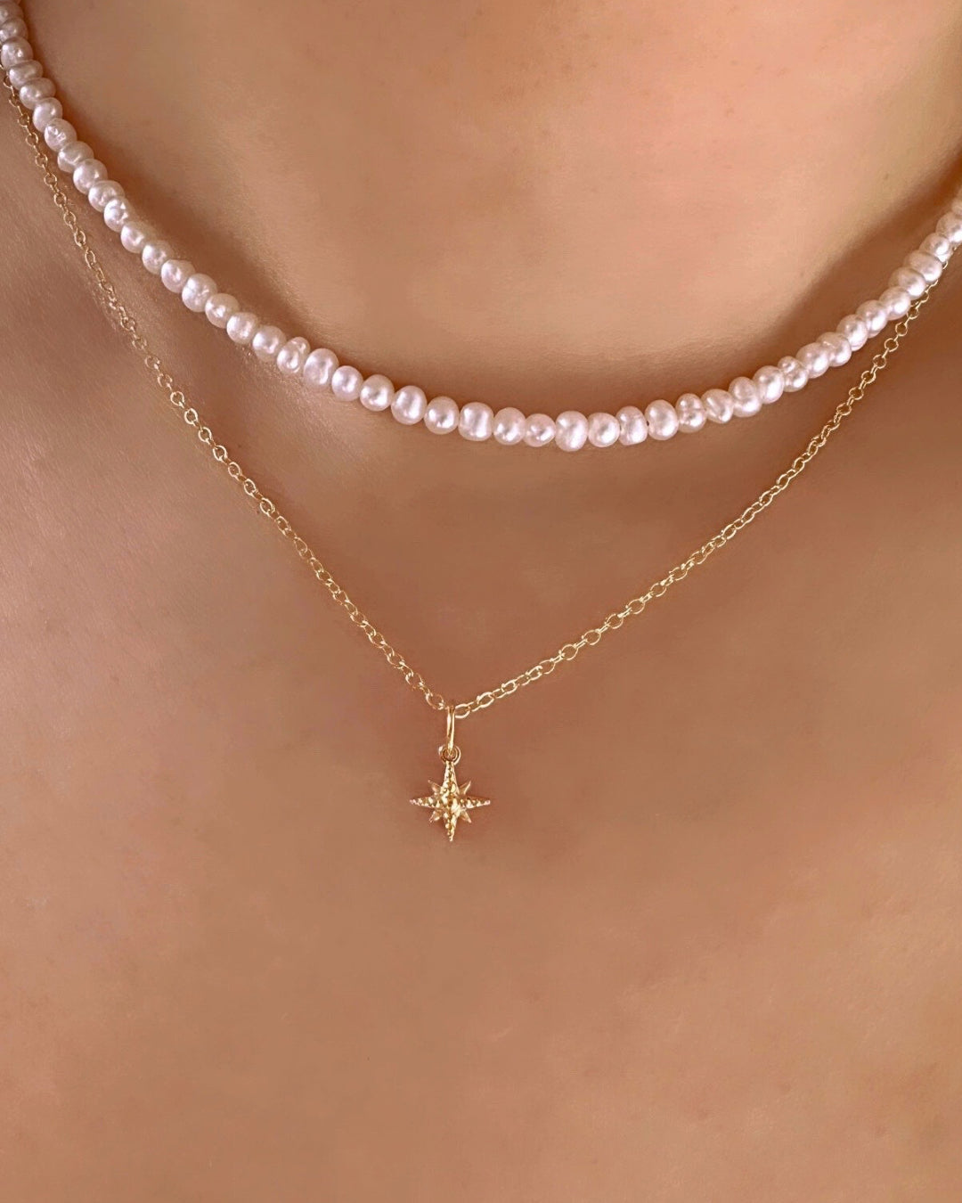 14k yellow solis gold North Star pendant charm on a 14k solid gold necklace chain on a model 