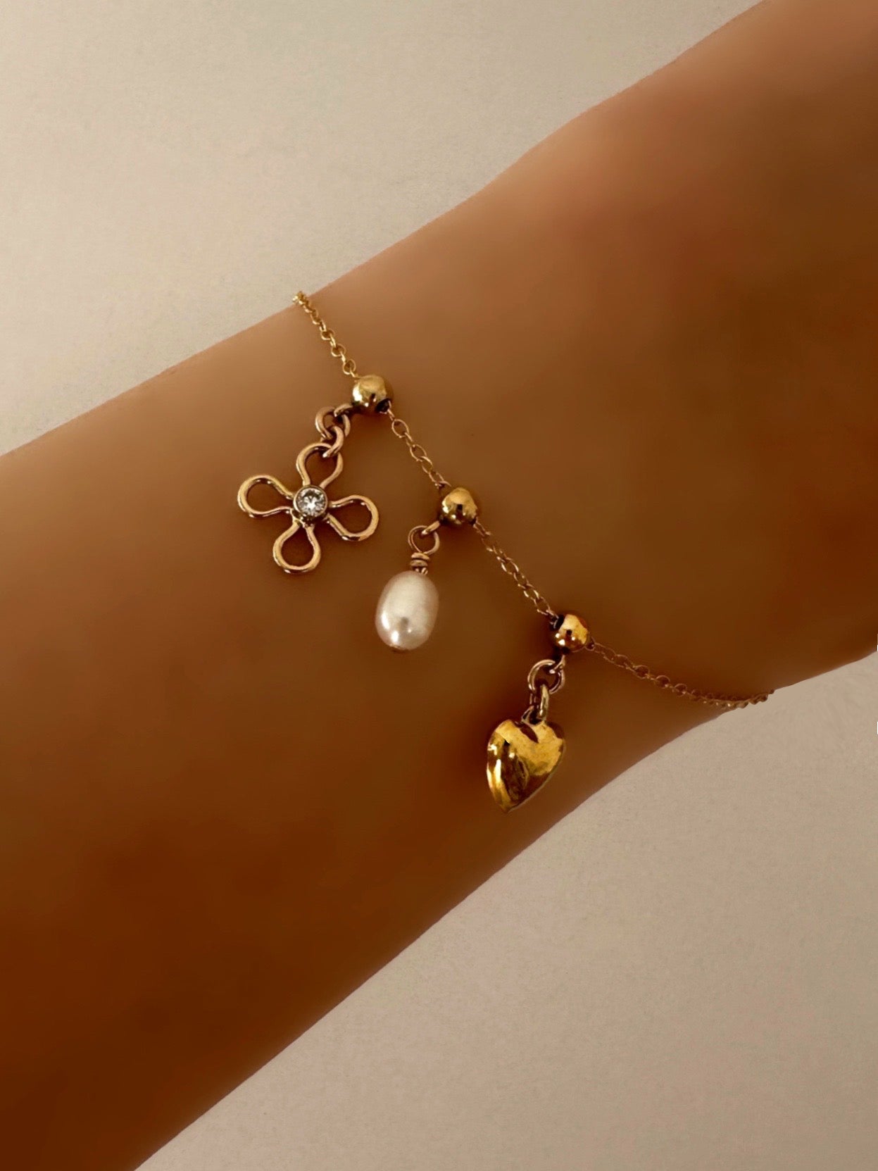 Model wearing 14k gold fill petal charm on a Charm Story Bead Bracelet