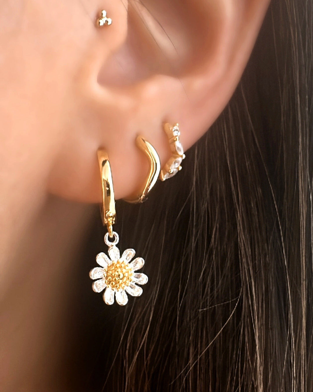 Model wearing Gold Daisy Bloom Hoops by Romyli, dainty gold vermeil hoop earrings with sterling silver daisy charms and gold centres. Lightweight floral earrings for everyday wear.