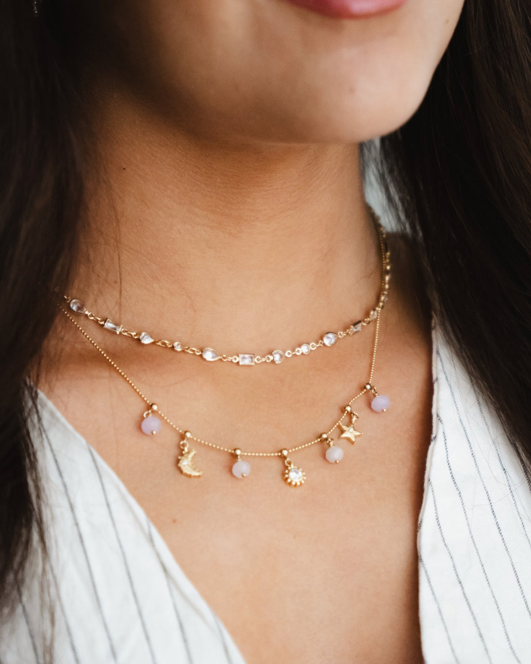 Rose Quartz Heart Charm on a Charm Story Cable Chain Bracelet, stacked with meaningful gold and semi precious charms on a model. 