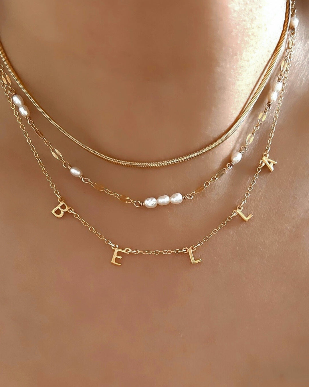 Customisable gold-filled necklace featuring a mix of initial name letters. 