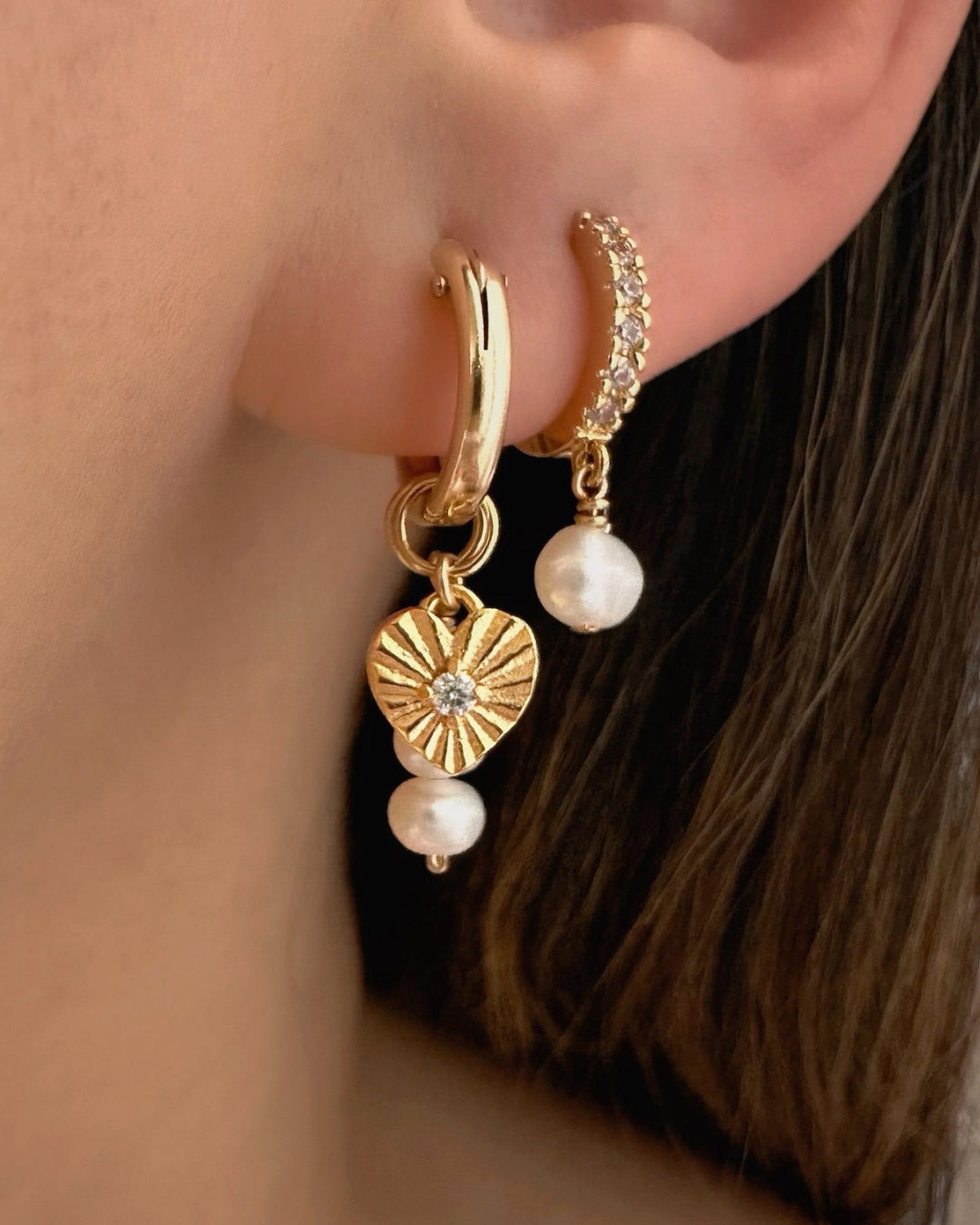 14k gold filled Mini Euro Hoops paired with Love Amulet and Pearl Trio Earring Charms on a model. Model is also wearing Pave Pearl Drop Huggies in her second lobe piercing. 