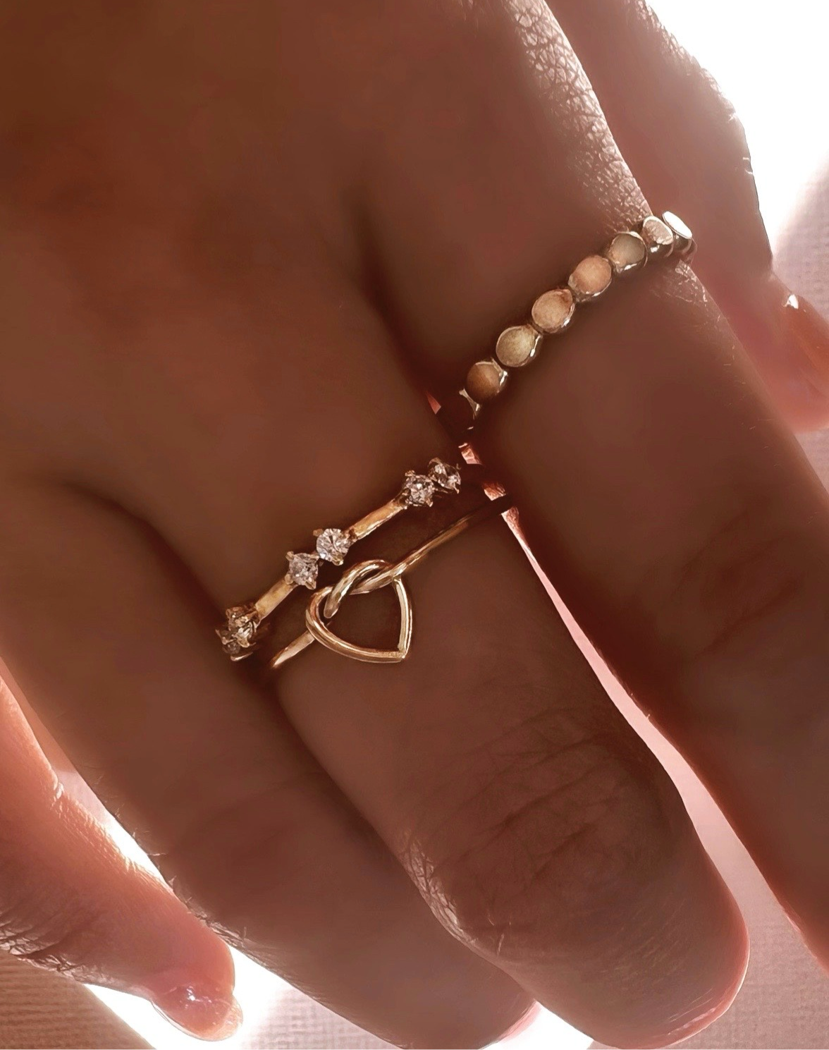 14k gold fill love heart knot stacking ring on a model. 