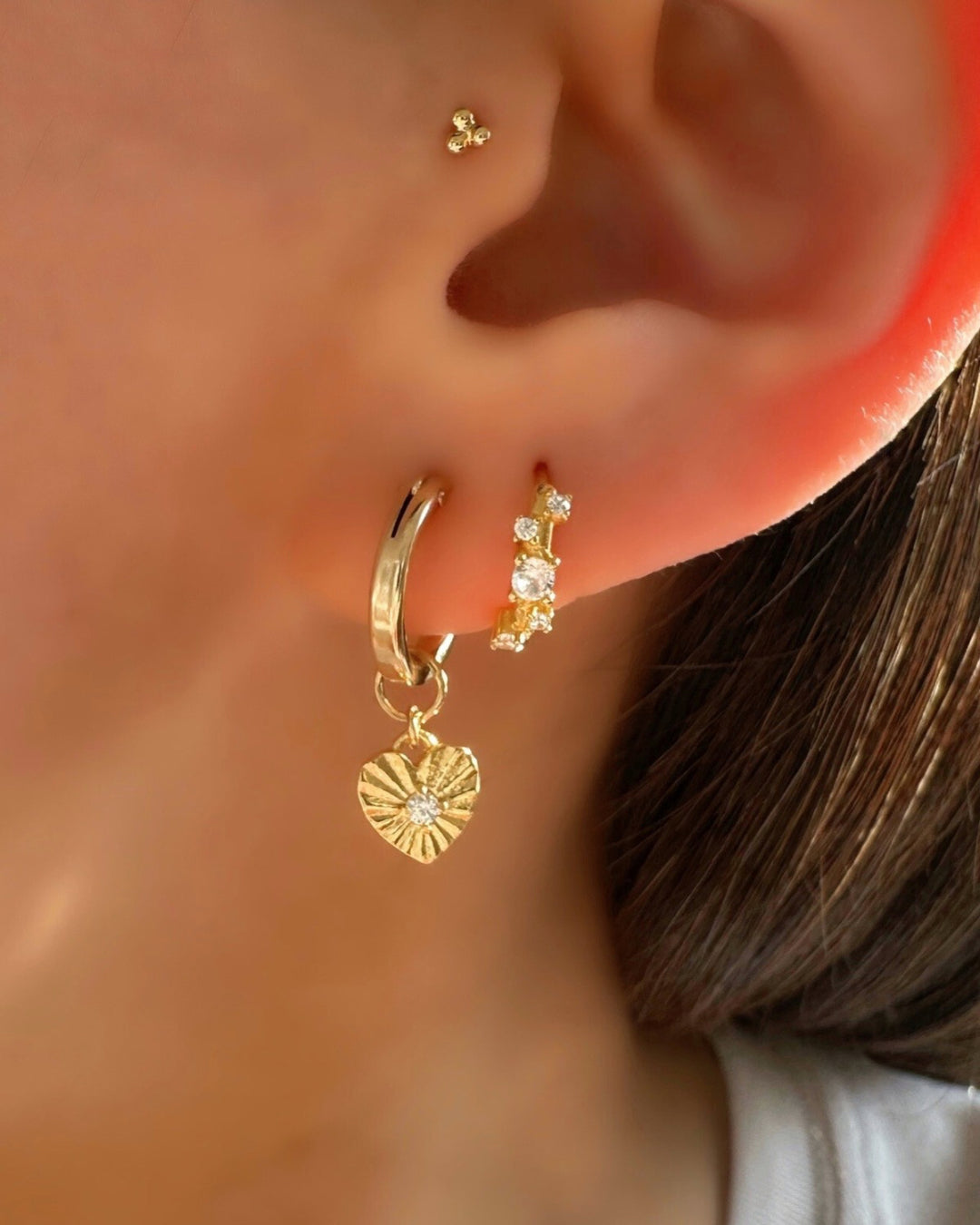 14k gold fill love amulet charm hoops with Stellar Cluster Huggies on a model.