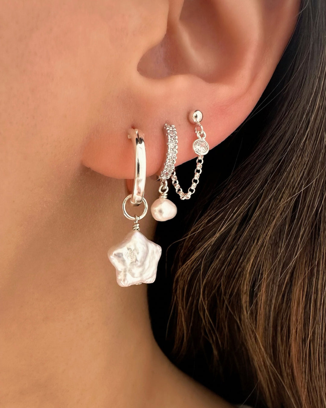Model wearing silver pavé huggie hoop earrings with organic freshwater pearl drop – sterling silver vermeil huggies set with cubic zirconia and baroque pearl charm.