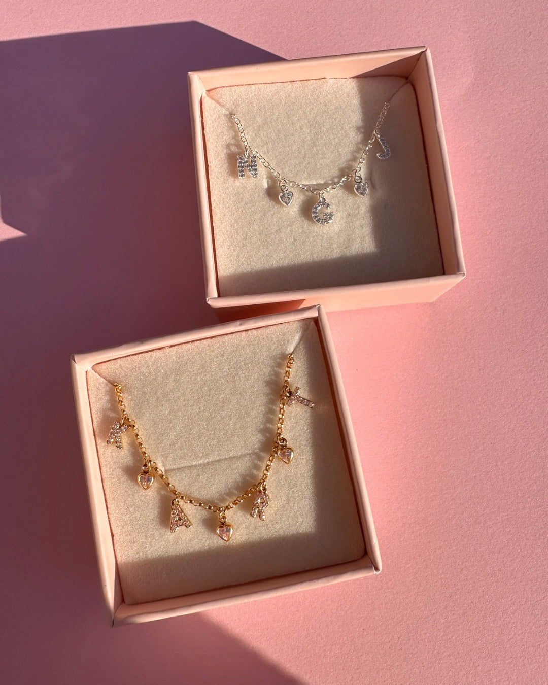 Gold and silver pavé initial bracelets with custom letters and heart charms displayed in jewellery box, personalised gift-ready jewellery for everyday wear