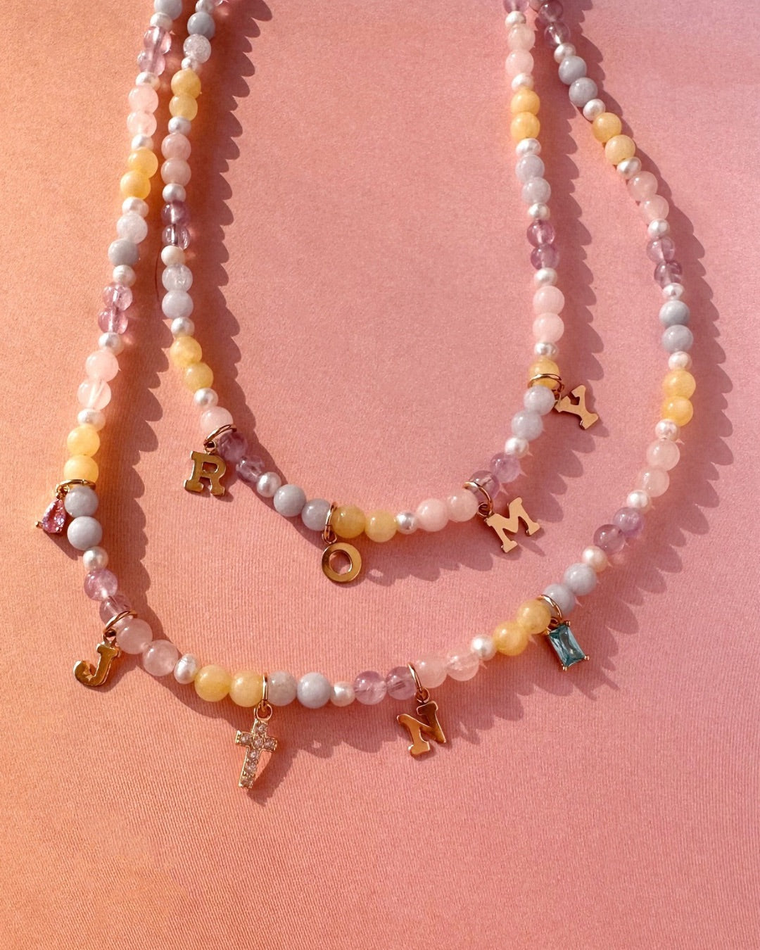 Pastel Gem Charm Necklaces on a pink background