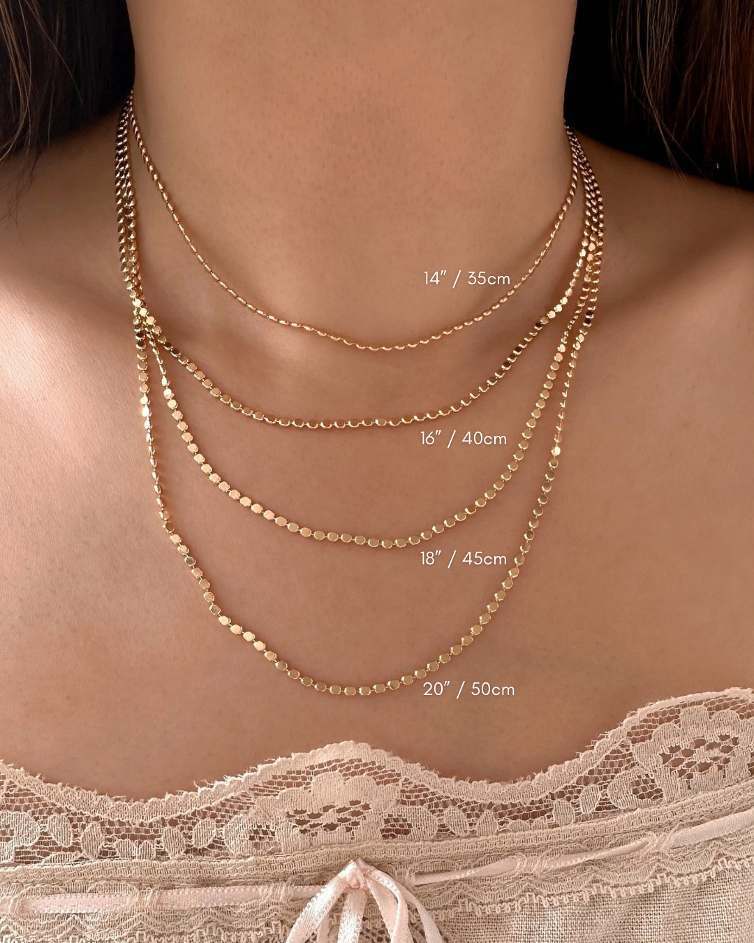 Gold petite faceted reflective choker necklace on a model. Featuring 4 different lengths - 14” , 16”, 18” and 20”