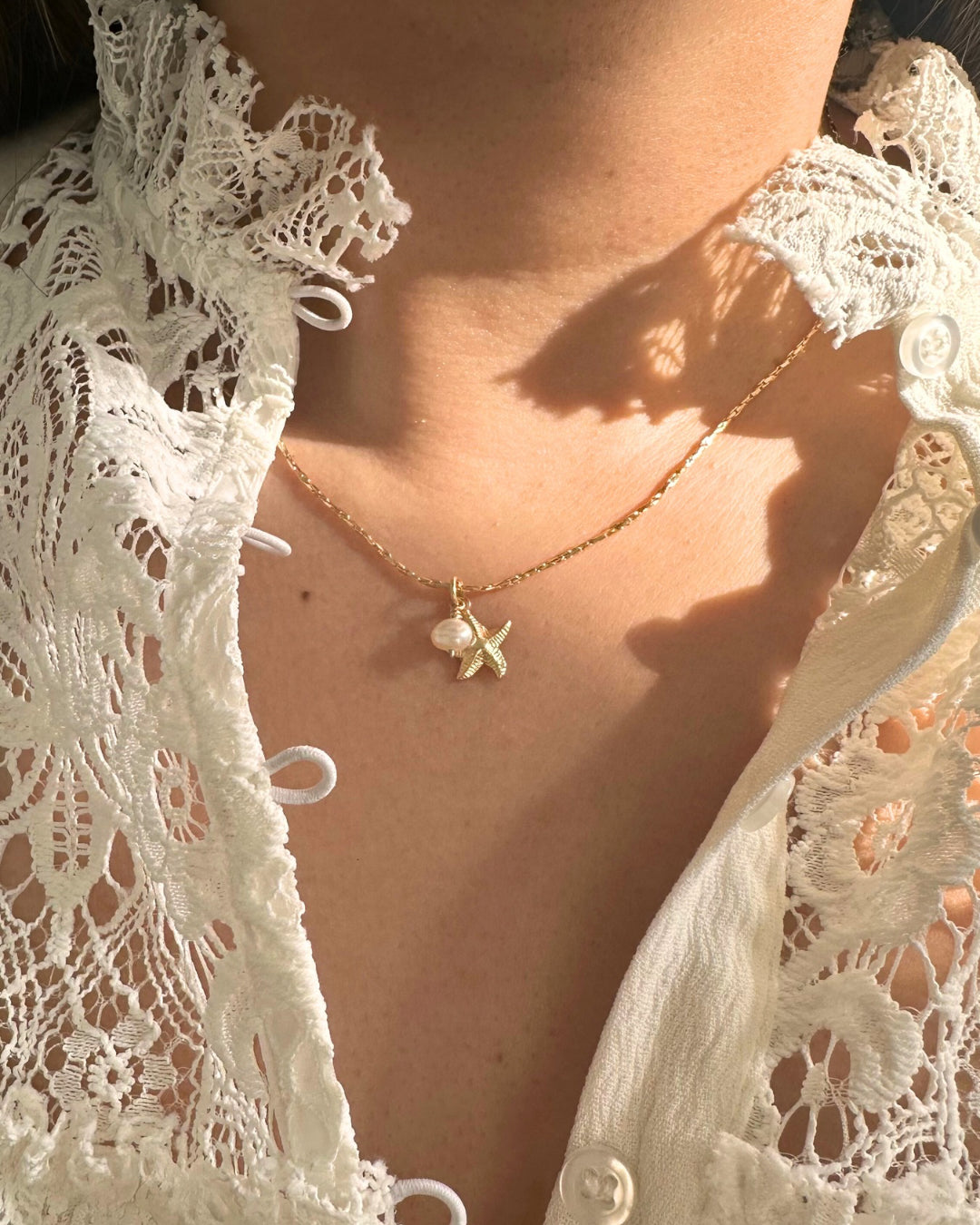 Model wears gold starfish and pearl charm necklace on dainty gold chain. Made in Australia 