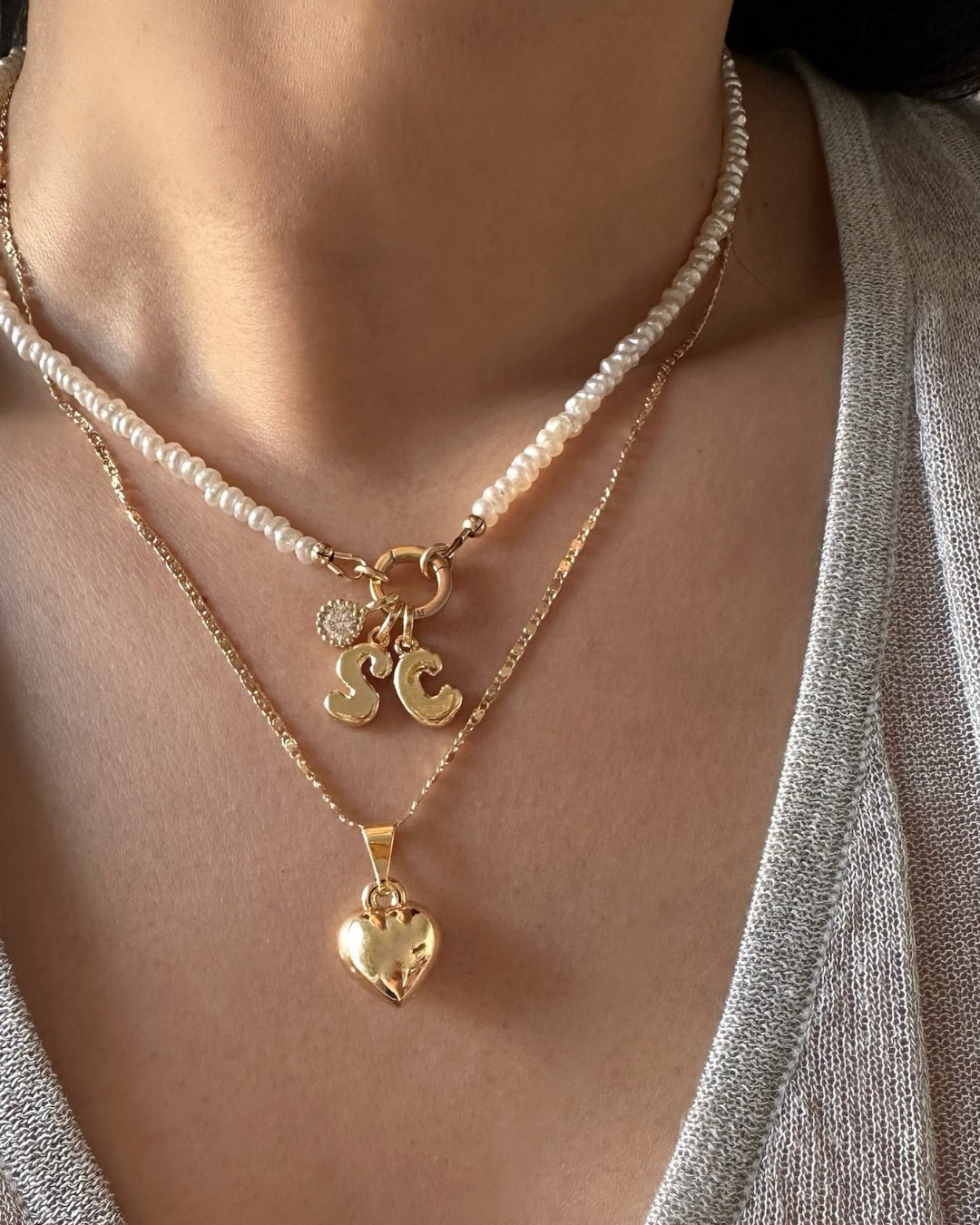 Model wearing Gold Mini Pearl Charm Holder Necklace with Birthstone and Bubble Initial Pendant Charms. 