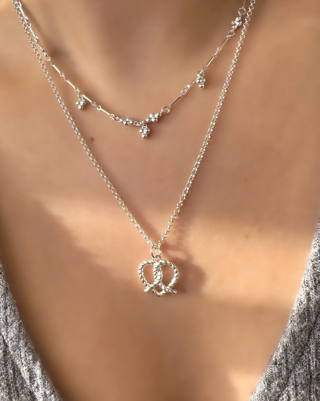 925 Sterling Silver Pretzel Heart Pendant on a silver Rolo necklace chain on a model