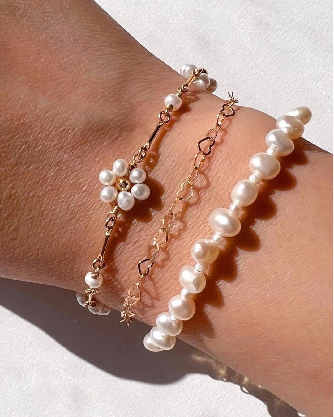 Freshwater Pearl Orb Bracelet stacked with Daisy Pearl Bracelet and Heart Link Bracelet 