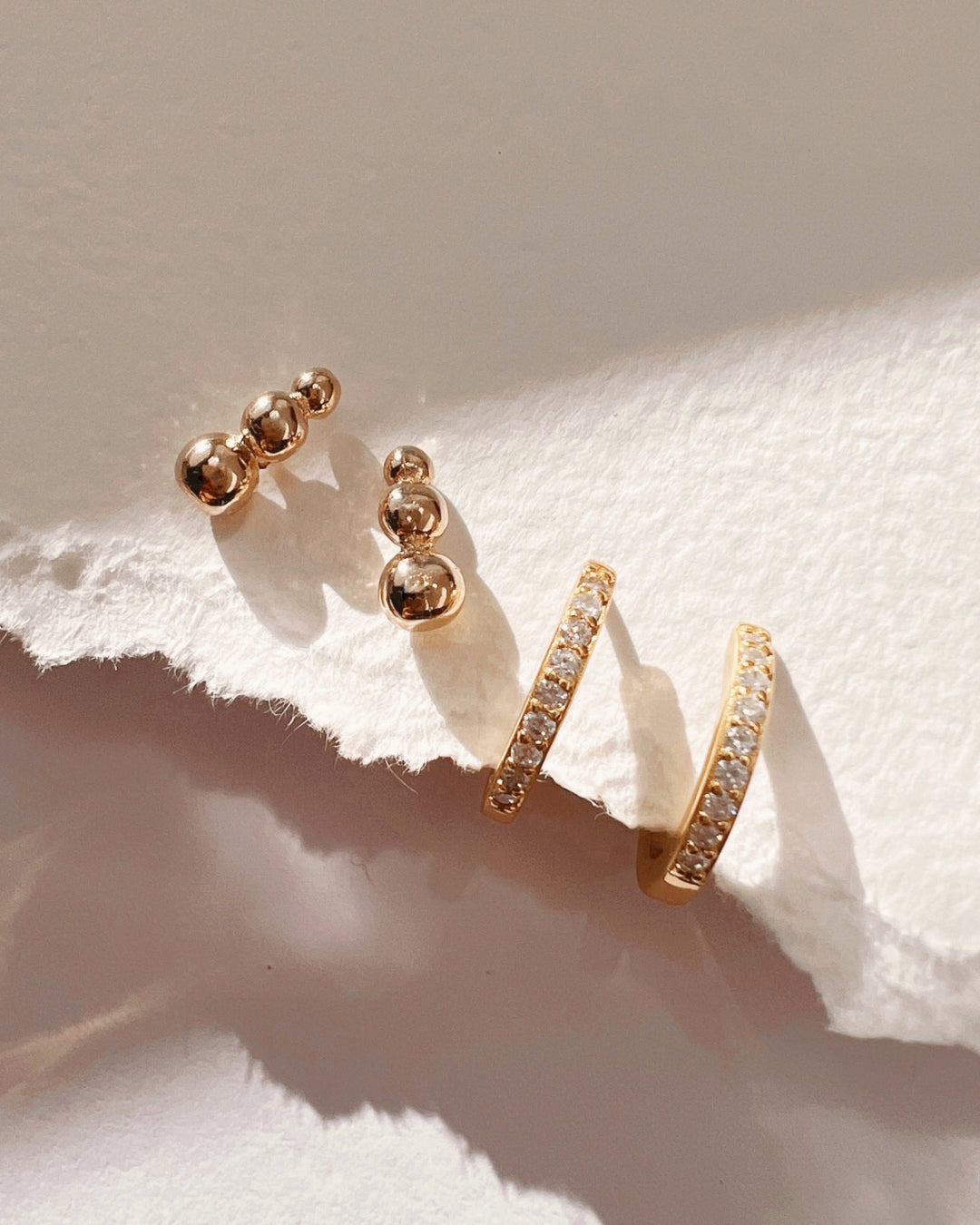 Gold cubic zirconia crystal pave Huggie Hoop Earrings stacked with gold stud earrings