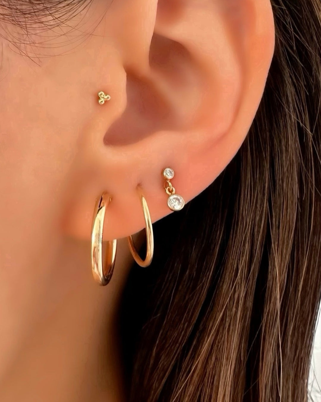 14k Solid gold infinity hoops earrings on a model