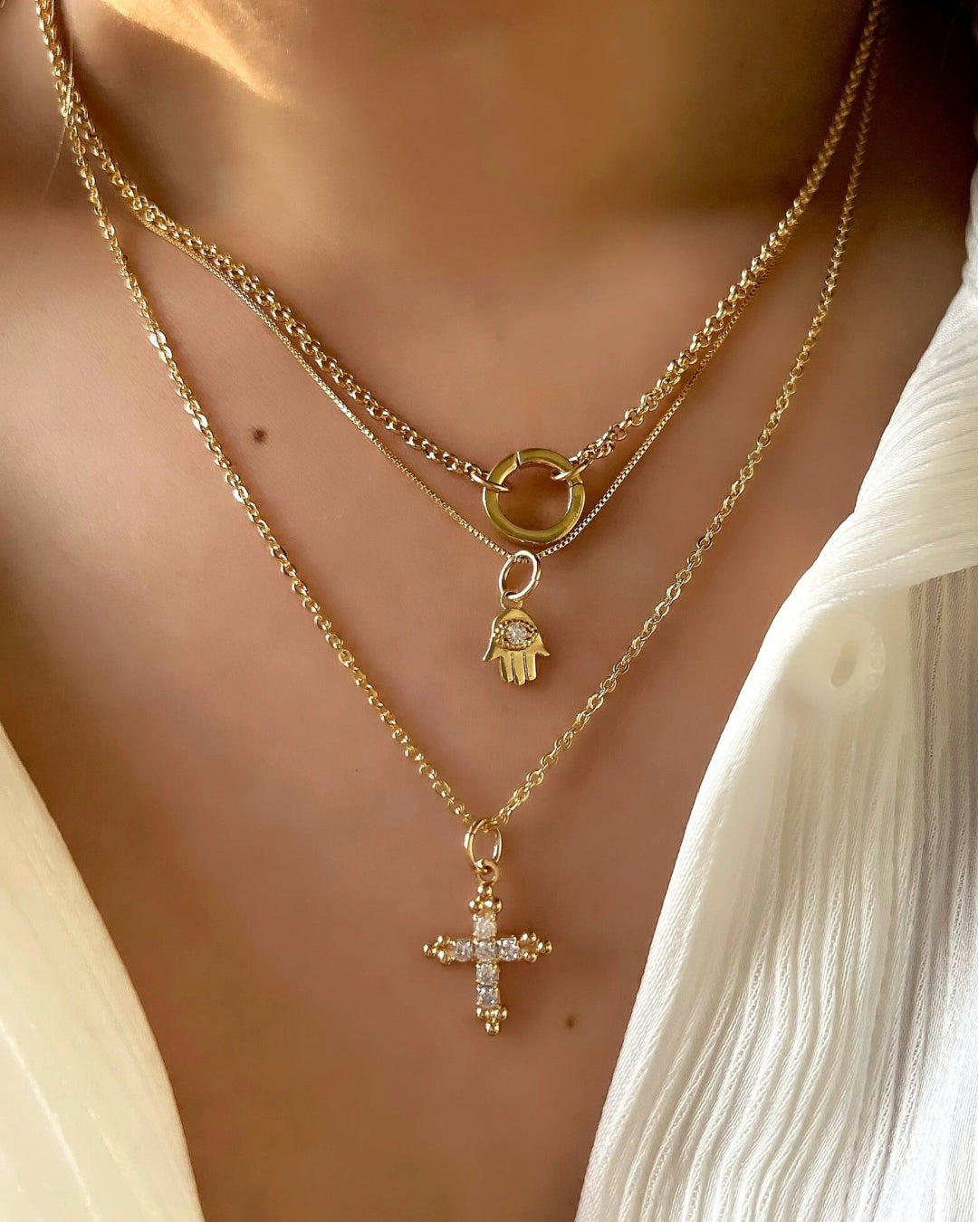 Gold fill cross talisman pendant on a gold cable chain necklace on a model 