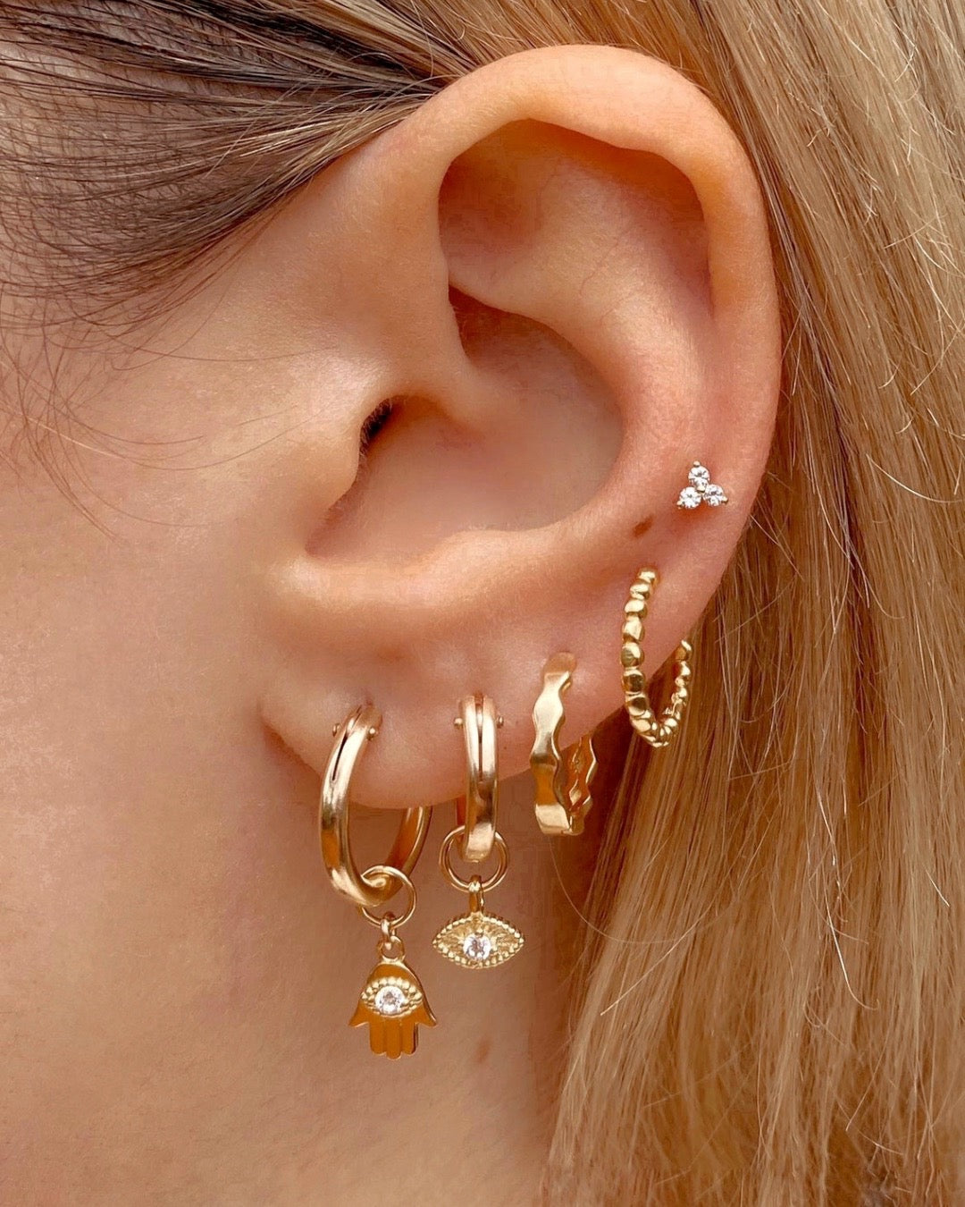 14k yellow gold fill talisman evil eye charm hoops earrings on a model 